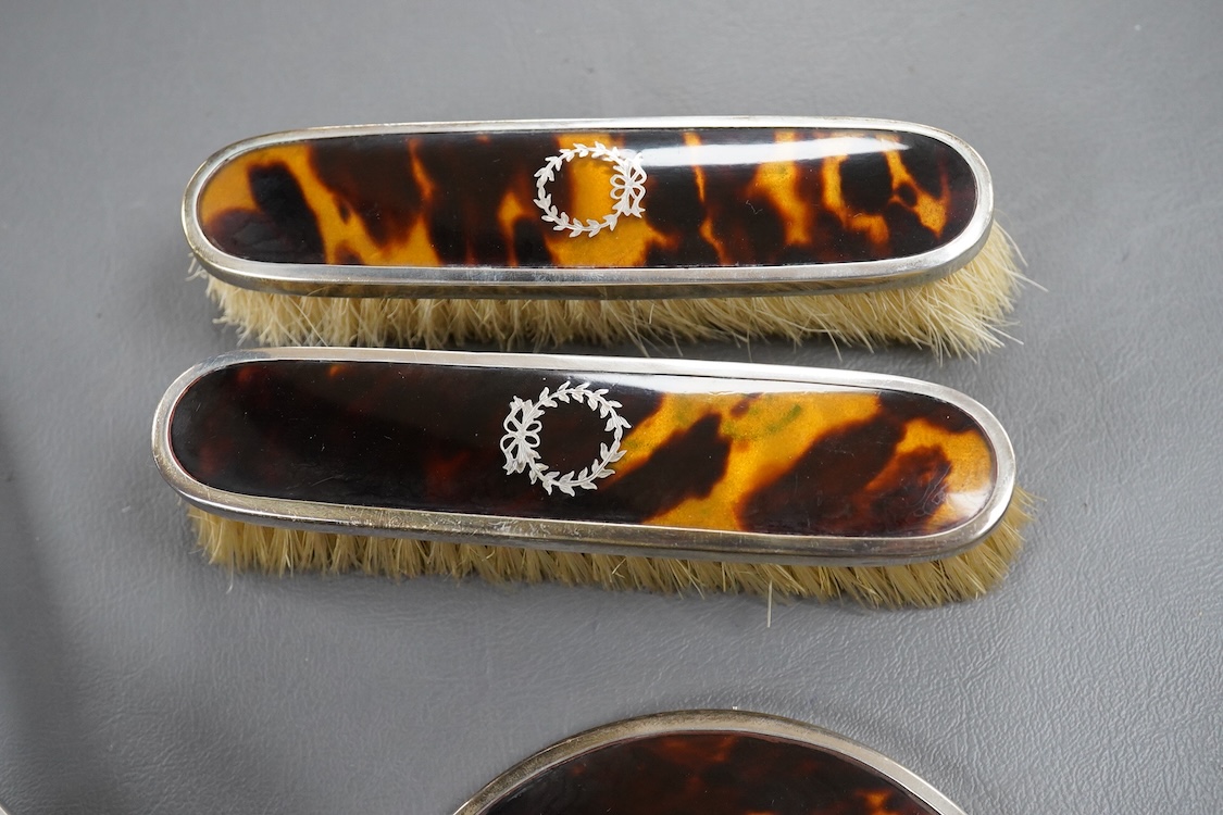A matched George V silver and tortoiseshell mounted four piece mirror and brush set, Birmingham, 1927/8/9, mirror 22.7cm.